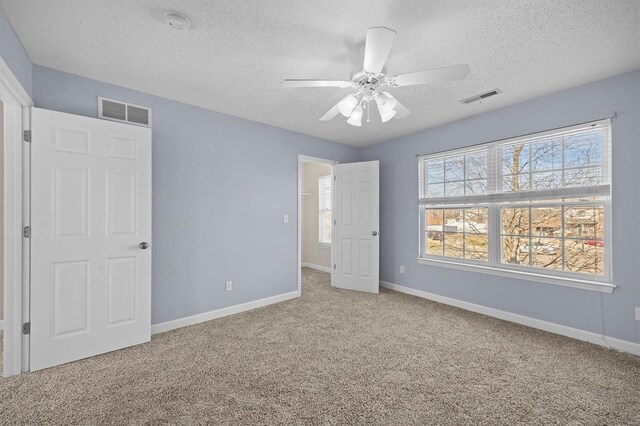 unfurnished bedroom with ceiling fan, a textured ceiling, and carpet flooring