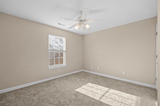 empty room with ceiling fan, carpet floors, and a textured ceiling