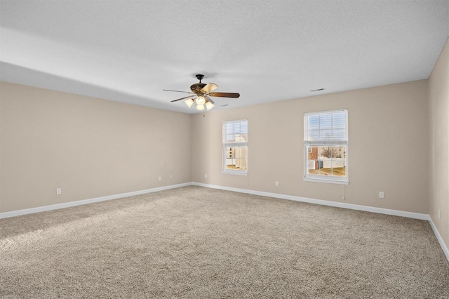 carpeted empty room featuring ceiling fan and a textured ceiling