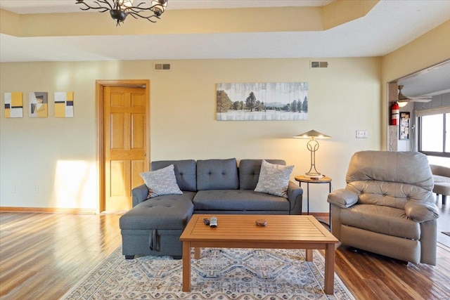 living room with hardwood / wood-style floors and a notable chandelier