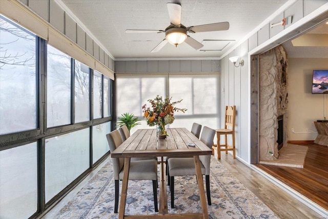 sunroom with a wealth of natural light, a fireplace, and ceiling fan