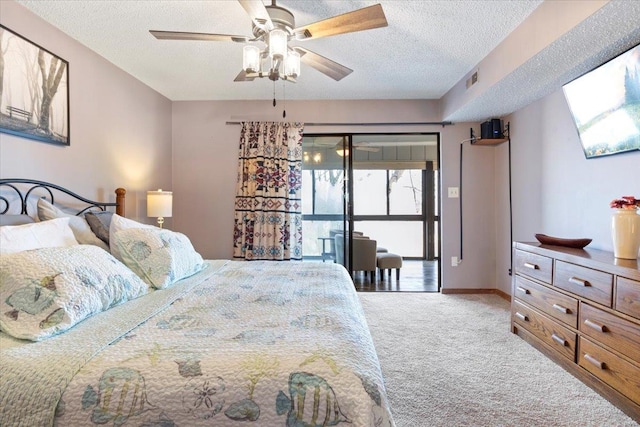 carpeted bedroom with ceiling fan and a textured ceiling