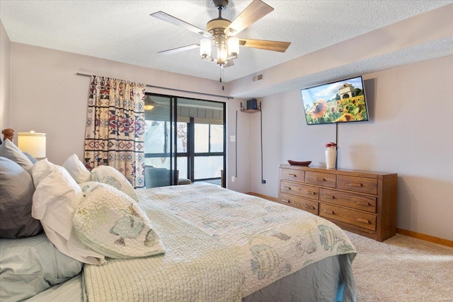 carpeted bedroom featuring a textured ceiling and ceiling fan