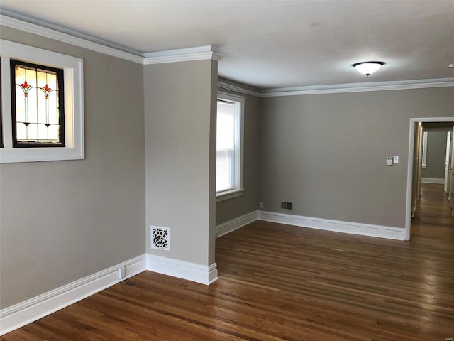 spare room featuring dark hardwood / wood-style flooring and crown molding