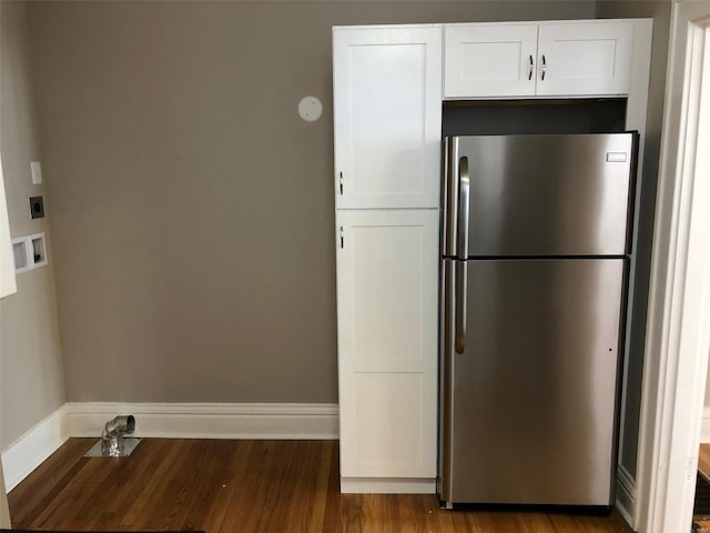 kitchen with stainless steel refrigerator, white cabinets, and wood-type flooring