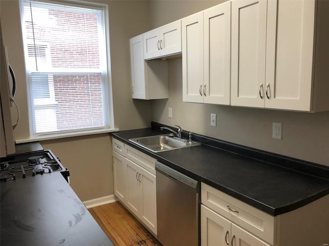 kitchen featuring white gas range, sink, stainless steel dishwasher, wood-type flooring, and white cabinets