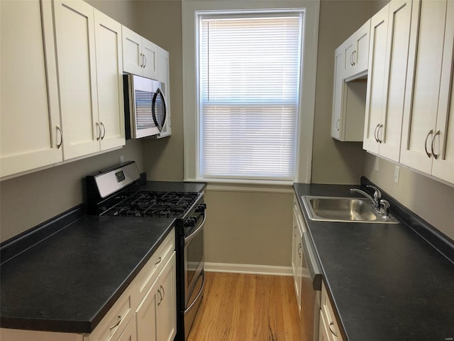 kitchen with white cabinetry, sink, stainless steel appliances, and light hardwood / wood-style floors