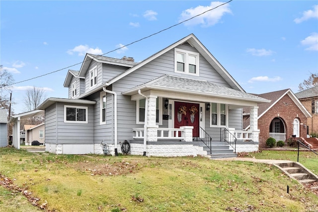 bungalow-style home with covered porch and a front yard