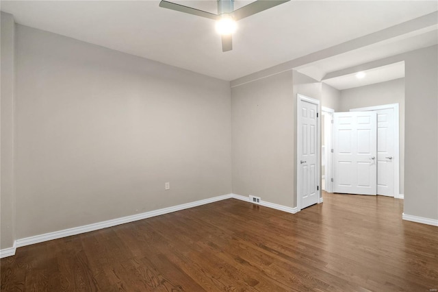 empty room featuring ceiling fan and dark wood-type flooring