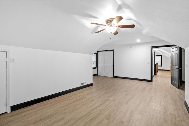 additional living space with vaulted ceiling, light hardwood / wood-style flooring, and ceiling fan