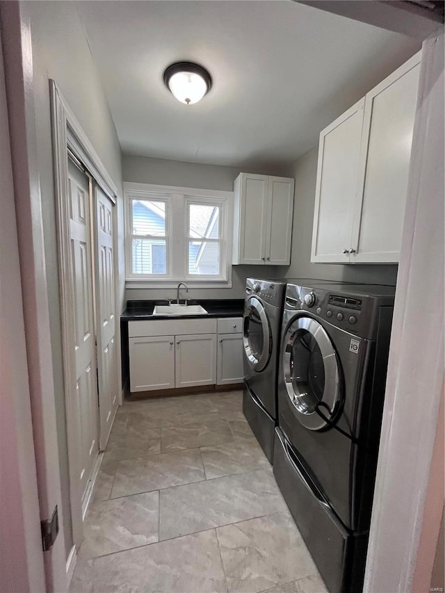 clothes washing area featuring cabinets, washing machine and clothes dryer, and sink