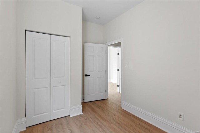 unfurnished bedroom featuring a closet and light wood-type flooring