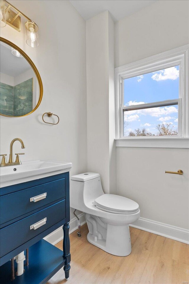 bathroom with toilet, vanity, and hardwood / wood-style flooring