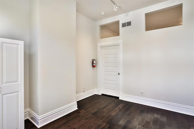 interior space featuring rail lighting and dark wood-type flooring