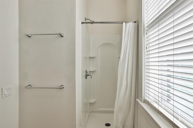 bathroom featuring a shower with shower curtain and a healthy amount of sunlight