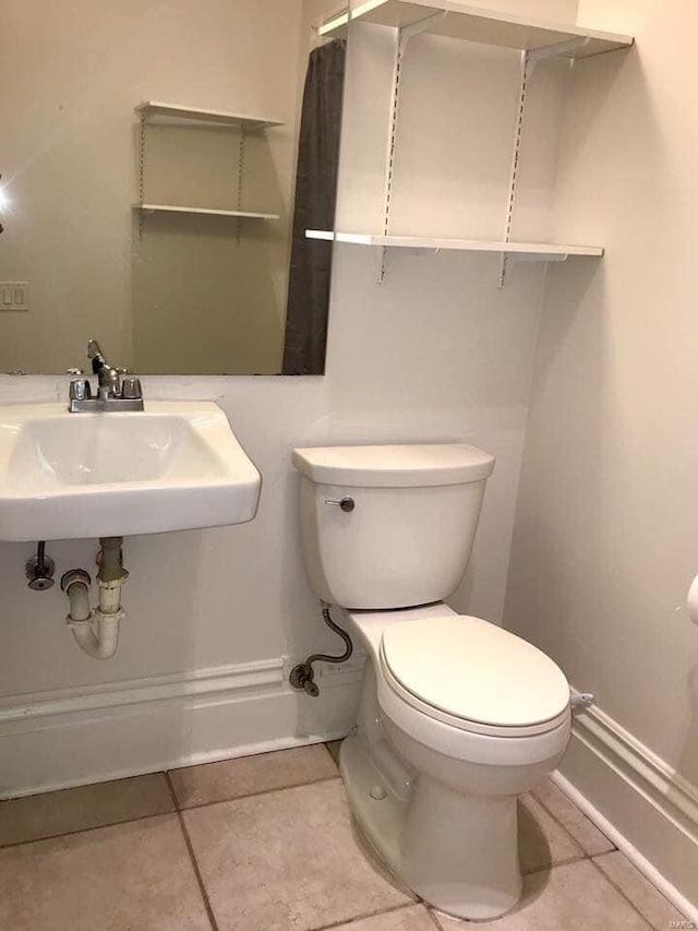 bathroom with tile patterned flooring, toilet, and sink