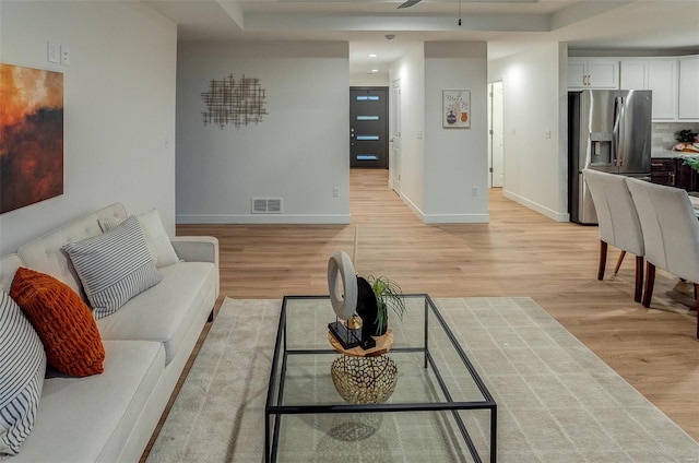 living room with ceiling fan and light hardwood / wood-style flooring