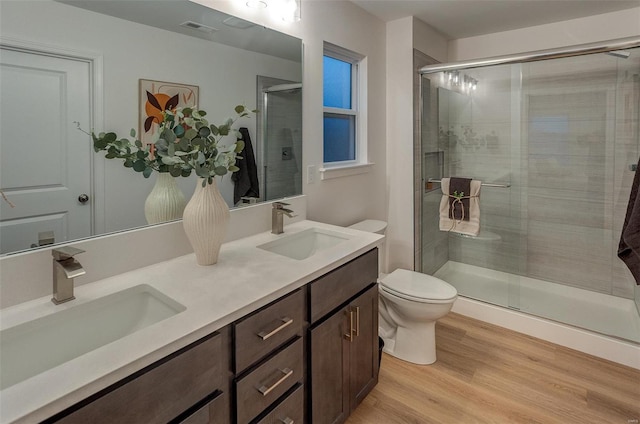 bathroom with walk in shower, vanity, wood-type flooring, and toilet