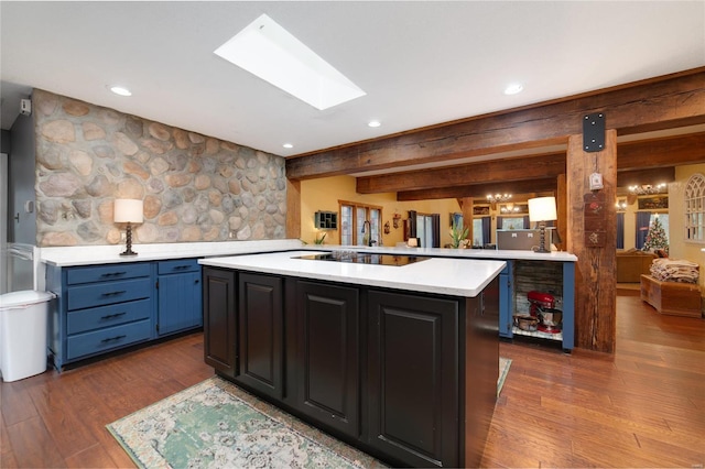 kitchen featuring hardwood / wood-style floors, a center island, beam ceiling, and kitchen peninsula