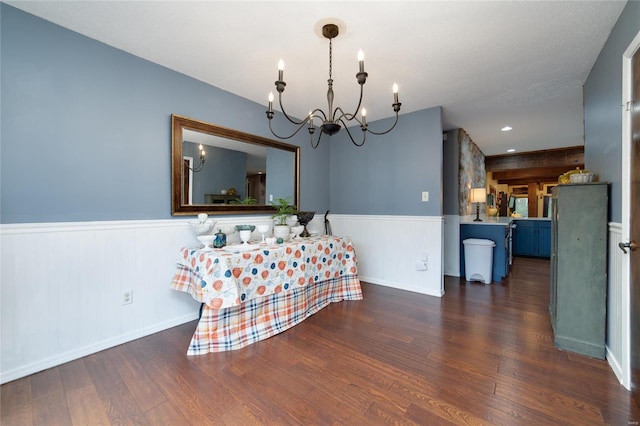 dining space with dark hardwood / wood-style floors, a textured ceiling, and an inviting chandelier