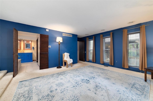 unfurnished bedroom featuring ensuite bath and light colored carpet