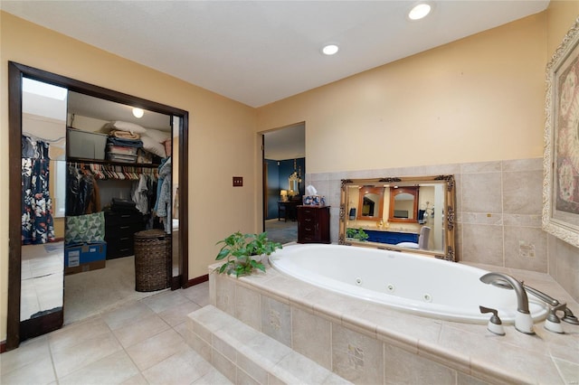 bathroom with a relaxing tiled tub and tile patterned floors