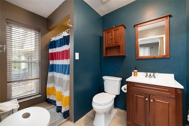 bathroom featuring tile patterned floors, a healthy amount of sunlight, and a textured ceiling