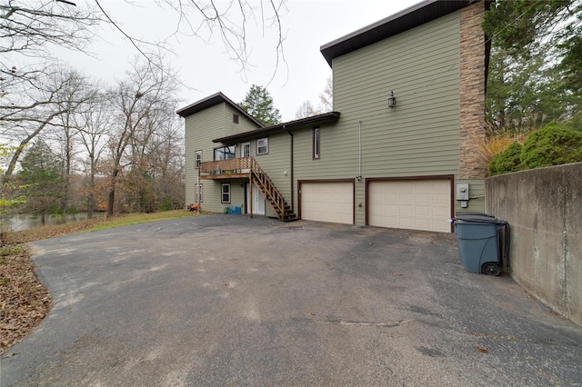 back of property featuring a garage and a deck