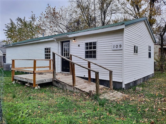 back of property featuring a wooden deck and cooling unit