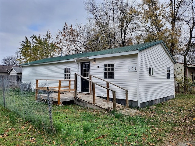 rear view of house featuring a wooden deck