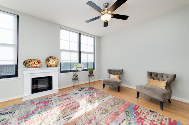 living area with ceiling fan and light hardwood / wood-style flooring