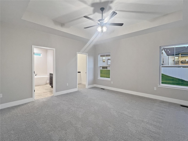 unfurnished bedroom with connected bathroom, light colored carpet, and ceiling fan