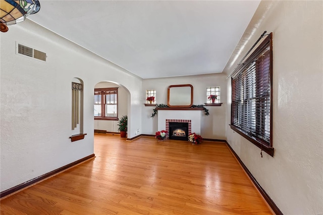 unfurnished living room featuring a fireplace and light hardwood / wood-style flooring