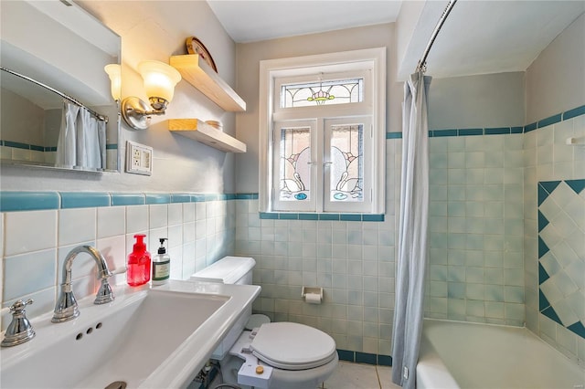 full bathroom featuring french doors, sink, toilet, shower / tub combo with curtain, and tile walls