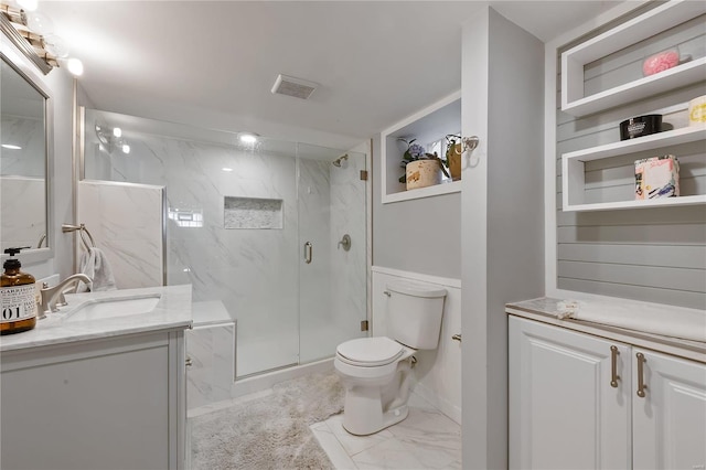 bathroom with a shower with door, vanity, and toilet