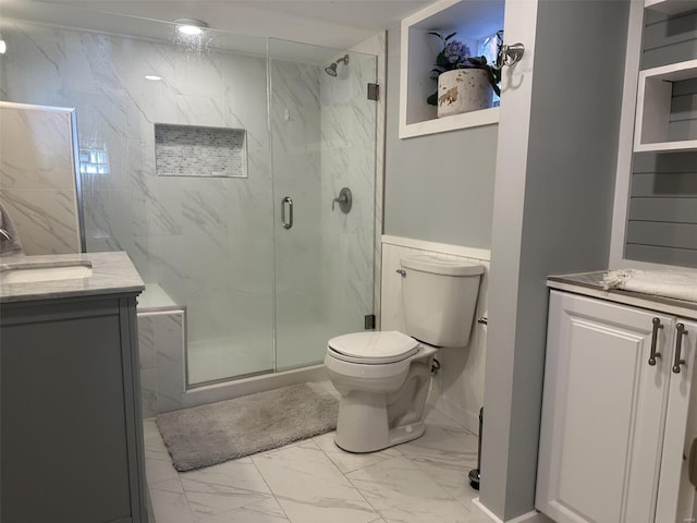 bathroom with vanity, toilet, and a shower with door