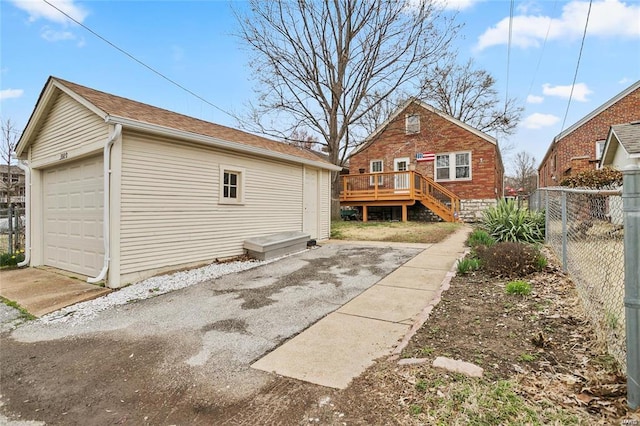 rear view of house with an outbuilding, a garage, and a deck