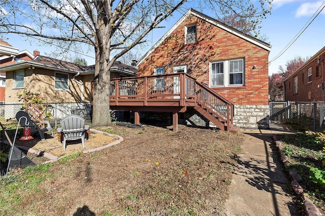 rear view of house featuring a wooden deck