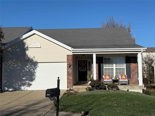 view of front of property featuring a front lawn, covered porch, and a garage