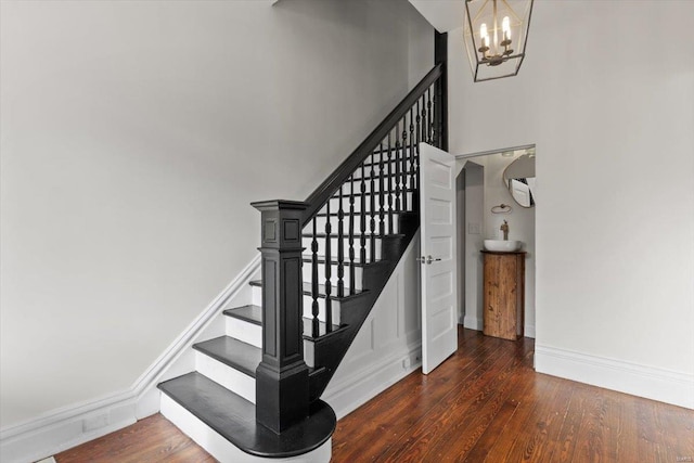 stairway featuring hardwood / wood-style flooring and a chandelier