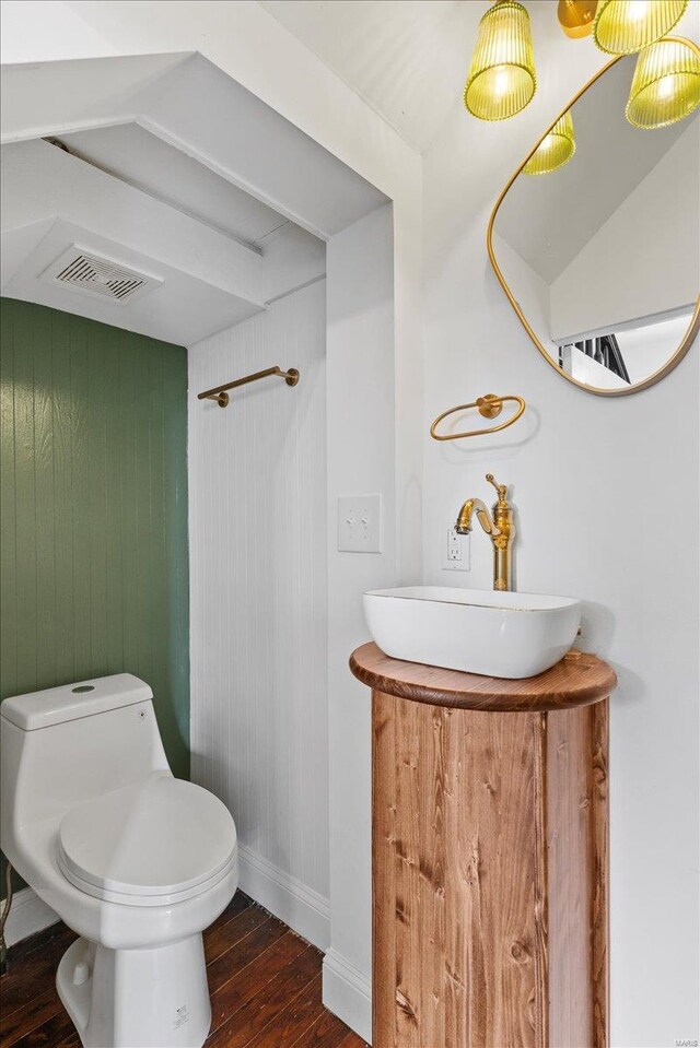 bathroom with wood walls, toilet, vanity, and hardwood / wood-style flooring