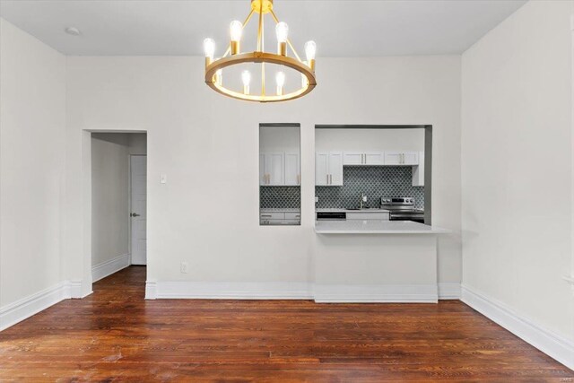 spare room featuring a notable chandelier, dark hardwood / wood-style flooring, and sink