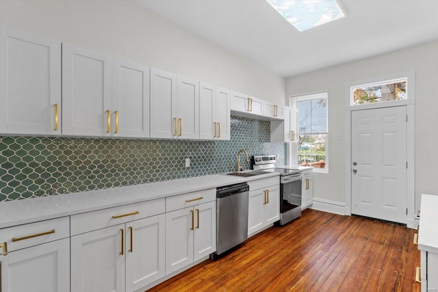 kitchen with white cabinets, dark hardwood / wood-style flooring, stainless steel appliances, and sink