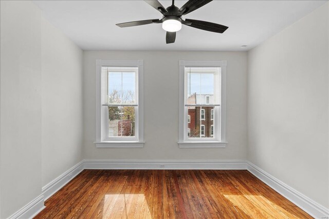 spare room featuring ceiling fan, plenty of natural light, and dark wood-type flooring