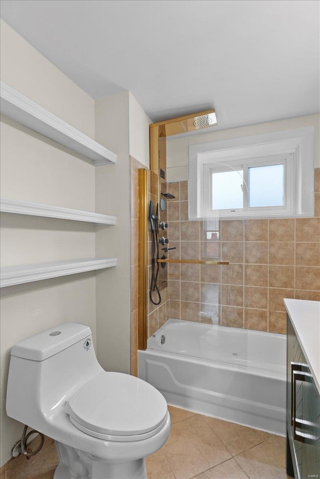 bathroom with tile patterned flooring, tiled shower / bath combo, and toilet