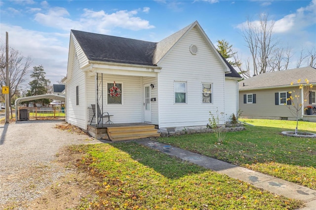 bungalow-style home featuring a front yard and a carport