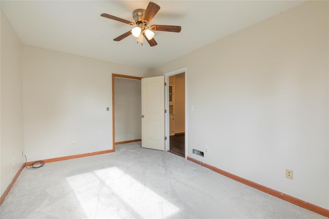 unfurnished bedroom featuring ceiling fan, a closet, and light carpet