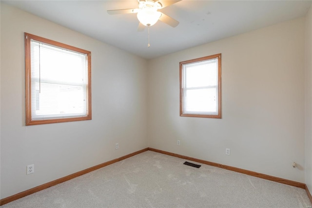 unfurnished room with light colored carpet and ceiling fan