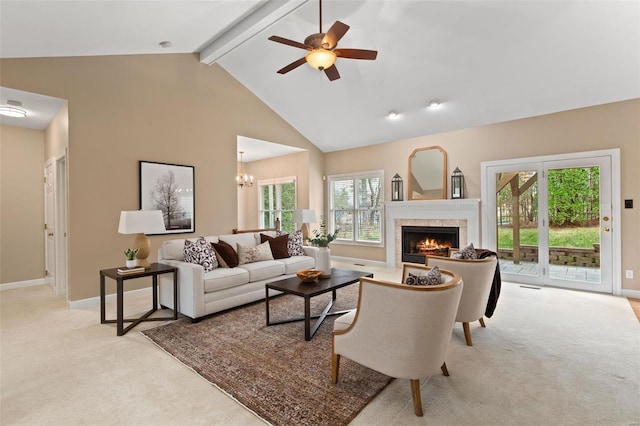 carpeted living room with a tile fireplace, beam ceiling, a healthy amount of sunlight, and high vaulted ceiling