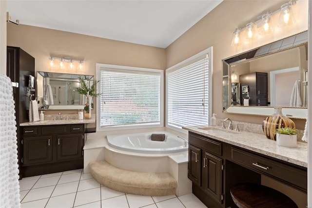 bathroom with tile patterned flooring, vanity, and tiled tub